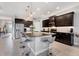 Open kitchen boasting stainless steel appliances, dark cabinets, granite counters, and a large eat-in island at 16943 Rosedown Gln, Parrish, FL 34219