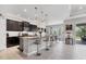 Spacious kitchen featuring dark cabinetry, granite countertops, pendant lighting, and an eat-in island with barstools at 16943 Rosedown Gln, Parrish, FL 34219