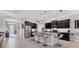 Bright kitchen featuring pendant lighting, dark cabinetry, stainless steel appliances, and an island with bar seating at 16943 Rosedown Gln, Parrish, FL 34219
