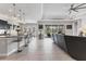 Open-concept living space with tiled floors, a modern ceiling fan, and a seamless transition to the outdoors at 16943 Rosedown Gln, Parrish, FL 34219