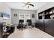 Office space with two desks, a ceiling fan, tile floors, and a black cabinet at 16943 Rosedown Gln, Parrish, FL 34219