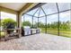 Screened-in patio featuring an outdoor kitchen and brick-paved flooring at 16943 Rosedown Gln, Parrish, FL 34219