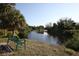 Scenic river view with lush green trees and a charming park bench to take in the serene landscape at 16943 Rosedown Gln, Parrish, FL 34219