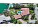Aerial view of a home with a tile roof, lush landscaping, a pool, and waterfront access at 203 Robin Dr, Sarasota, FL 34236