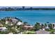 Picturesque aerial view of waterfront home, boasting a terracotta roof amidst lush greenery and the expansive bay at 203 Robin Dr, Sarasota, FL 34236