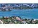 Stunning aerial view of a waterfront home with tile roof surrounded by lush trees and the sparkling bay at 203 Robin Dr, Sarasota, FL 34236