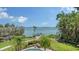Waterfront home offering an inviting backyard with mature palms, dock and seating to take in water views at 203 Robin Dr, Sarasota, FL 34236