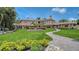 Expansive backyard featuring a lush lawn, mature landscaping, and a charming fountain with walkway leading to an elegant home at 203 Robin Dr, Sarasota, FL 34236