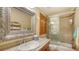 Elegant bathroom with a decorative framed mirror, tile countertops, and glass shower enclosure, offering a luxurious feel at 203 Robin Dr, Sarasota, FL 34236
