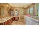 Luxurious bathroom features double sinks, a glass enclosed shower, and a separate soaking tub with a stained glass window at 203 Robin Dr, Sarasota, FL 34236