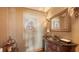 Elegant powder room boasts a decorative mirror, unique artwork, and a stylish vanity with a copper sink at 203 Robin Dr, Sarasota, FL 34236