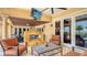 Cozy covered patio with a fireplace, seating area, and a view of the pool and waterfront at 203 Robin Dr, Sarasota, FL 34236