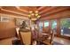 Elegant dining room with a view of the pool and a decorative chandelier hanging over the wooden table at 203 Robin Dr, Sarasota, FL 34236