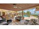 Covered patio with comfortable seating and a fireplace, overlooking a pool and waterfront, perfect for outdoor entertaining at 203 Robin Dr, Sarasota, FL 34236