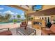 Outdoor living area featuring a fireplace, TV, and pool, perfect for relaxing and entertaining with a waterfront view at 203 Robin Dr, Sarasota, FL 34236