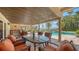 Covered patio dining area with a large table, comfortable chairs, and views of the pool and waterfront at 203 Robin Dr, Sarasota, FL 34236