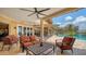 Inviting covered patio with comfortable seating, ceiling fans, and views of the pool and waterfront at 203 Robin Dr, Sarasota, FL 34236