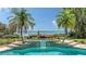 Inviting pool and spa with waterfront views framed by lush tropical landscaping and mature palm trees at 203 Robin Dr, Sarasota, FL 34236