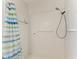 All-white tiled shower with a shower curtain, safety bars, and handheld shower head at 216 Matisse Cir, Nokomis, FL 34275
