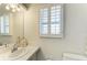 Bathroom vanity with a white sink, tiled countertop, shutters, and a decorative mirror at 216 Matisse Cir, Nokomis, FL 34275