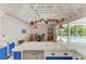 Bright, open kitchen with stainless steel appliances and unique hanging copper pot rack over a tile-top island at 216 Matisse Cir, Nokomis, FL 34275