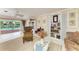 Cozy living room with floral wallpaper, bookshelves, and a sliding glass door view of the pool at 216 Matisse Cir, Nokomis, FL 34275