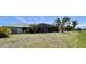 Expansive backyard with a screen-enclosed pool, lush greenery, and ample space for outdoor activities at 217 Mariner Ln, Rotonda West, FL 33947