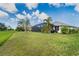 Exterior view of a well-maintained lawn that surrounds the home with a screened in pool at 217 Mariner Ln, Rotonda West, FL 33947