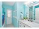 Bright turquoise bathroom with large mirror, marble vanity, and tub shower at 217 Mariner Ln, Rotonda West, FL 33947