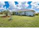A well-maintained house with a lush lawn and landscaping, palm trees, and well-maintained lawn at 217 Mariner Ln, Rotonda West, FL 33947