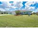 Landscaped front yard with a well-maintained lawn, mature palm trees, and flowering plants at 217 Mariner Ln, Rotonda West, FL 33947