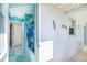 Hallway leading to a bathroom featuring a tub with colorful shower curtain and tile flooring at 217 Mariner Ln, Rotonda West, FL 33947