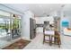 Spacious kitchen featuring a granite island with seating, stainless appliances, and easy access to outdoor pool area at 217 Mariner Ln, Rotonda West, FL 33947
