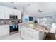 Open-concept kitchen with stainless appliances, granite island with seating, and seamless flow to living area at 217 Mariner Ln, Rotonda West, FL 33947