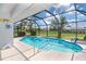 Sparkling pool within a screened enclosure, surrounded by lush landscaping and offering serene backyard views at 217 Mariner Ln, Rotonda West, FL 33947