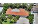 Aerial view of a one-story home boasting a terracotta roof, mature trees, an expansive driveway, and lush landscaping at 223 Seagull Ln, Sarasota, FL 34236