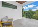 Covered outdoor balcony space with a modern chair, offering a serene treetop view at 2314 Floyd St, Sarasota, FL 34239