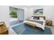 Bright bedroom boasts a king bed, a bench, a large sliding door, and seamless outdoor access at 2314 Floyd St, Sarasota, FL 34239
