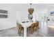 Bright dining room features a modern light fixture, white dining table, and a view of the living area for integrated entertaining at 2314 Floyd St, Sarasota, FL 34239