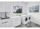 Bright laundry room with modern washer/dryer, sleek cabinetry, ample countertop space, and a large window at 2314 Floyd St, Sarasota, FL 34239