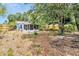 Spacious backyard with a screened porch, mature trees, and a wooden fence at 3205 33Rd Street W Ct, Bradenton, FL 34205