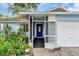 Inviting front entrance with a screened porch, colorful garden, and a vibrant blue front door at 3205 33Rd Street W Ct, Bradenton, FL 34205