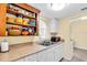 Functional kitchen with open shelving, stainless steel sink, and a view into the laundry area at 3205 33Rd Street W Ct, Bradenton, FL 34205