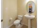 Half bathroom with a pedestal sink, toilet, and wall mirror at 3409 10Th W Ln, Palmetto, FL 34221
