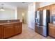 Kitchen featuring wooden cabinetry, stainless steel refrigerator, tiled floor and a half wall counter at 3409 10Th W Ln, Palmetto, FL 34221