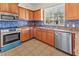 Well-lit kitchen featuring wooden cabinetry, granite countertops, and stainless steel appliances at 3409 10Th W Ln, Palmetto, FL 34221