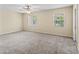 Spacious bedroom with carpet flooring, neutral walls, a ceiling fan, and two windows with plenty of natural light at 3409 10Th W Ln, Palmetto, FL 34221