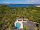 Aerial view of pool with lounge chairs, tropical trees, and partial ocean view at 3409 10Th W Ln, Palmetto, FL 34221