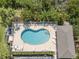 Aerial view of pool with lounge chairs, tropical trees, and nearby parking at 3409 10Th W Ln, Palmetto, FL 34221