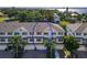 Charming two-story townhouse with red shutters, garages, and lush palm trees surrounding the property at 3409 10Th W Ln, Palmetto, FL 34221